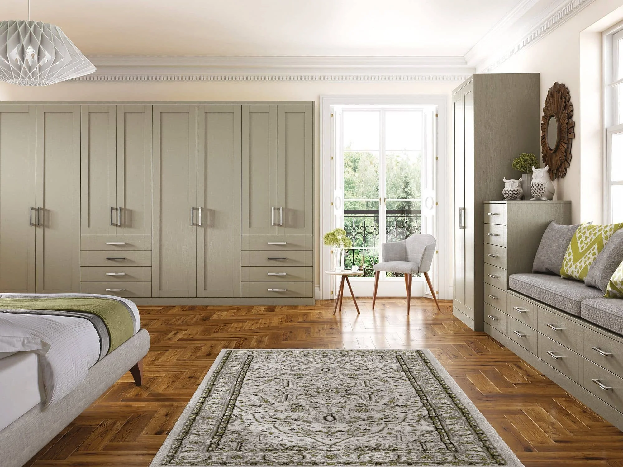 Room with large beige wardrobe, sitting area with chairs and small table near balcony door, wooden floor, rug, window with sunlight.