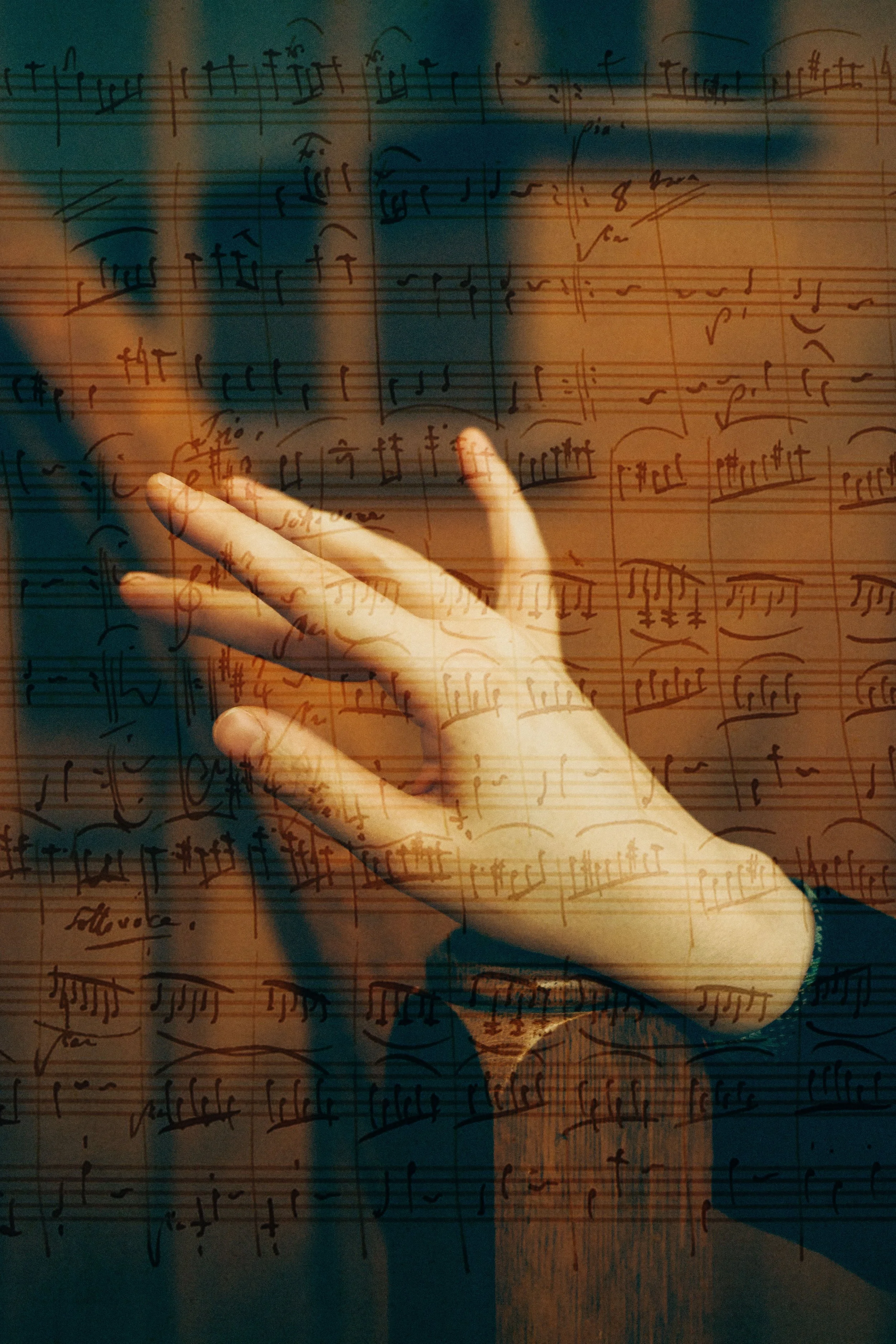 A hand with a ring on the ring finger is placed on a surface over sheet music, with a double exposure effect blending the person's hand and sheet music.