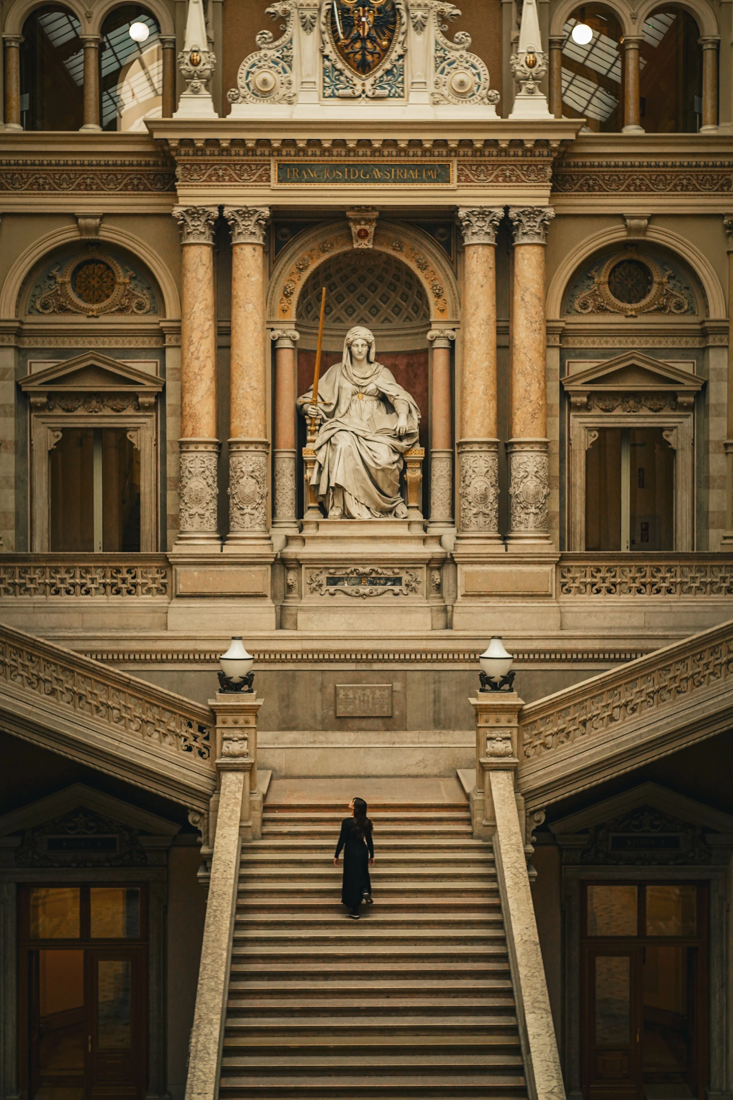 A fashion model ascending a grand staircase inside a historic building - fashion photoshooting Vienna