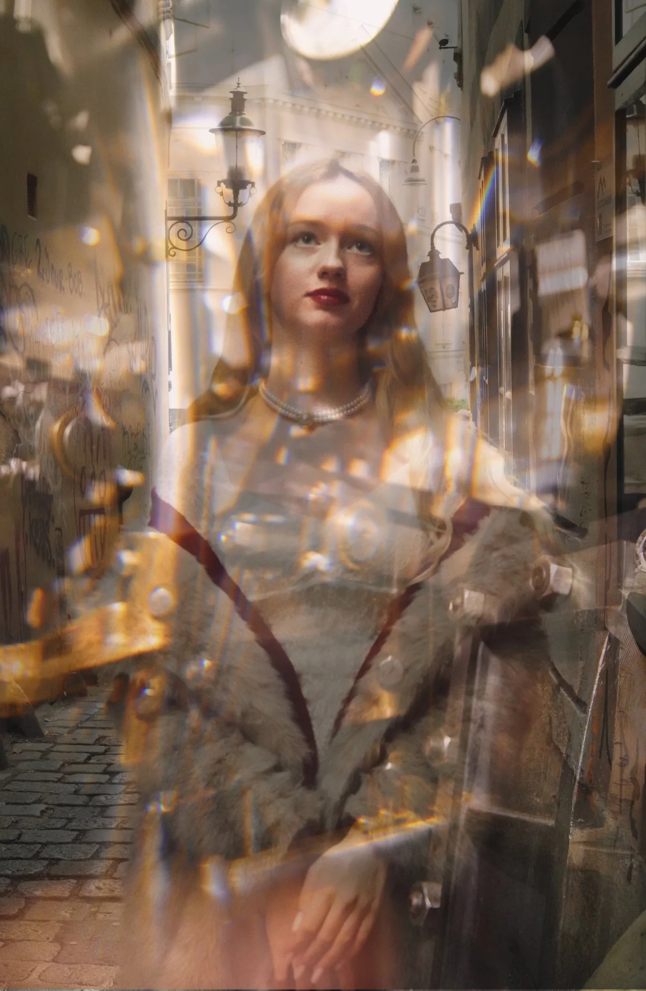 A woman with red hair, wearing a pearl necklace and a fur coat, standing behind a glass window with reflections and light distortions.