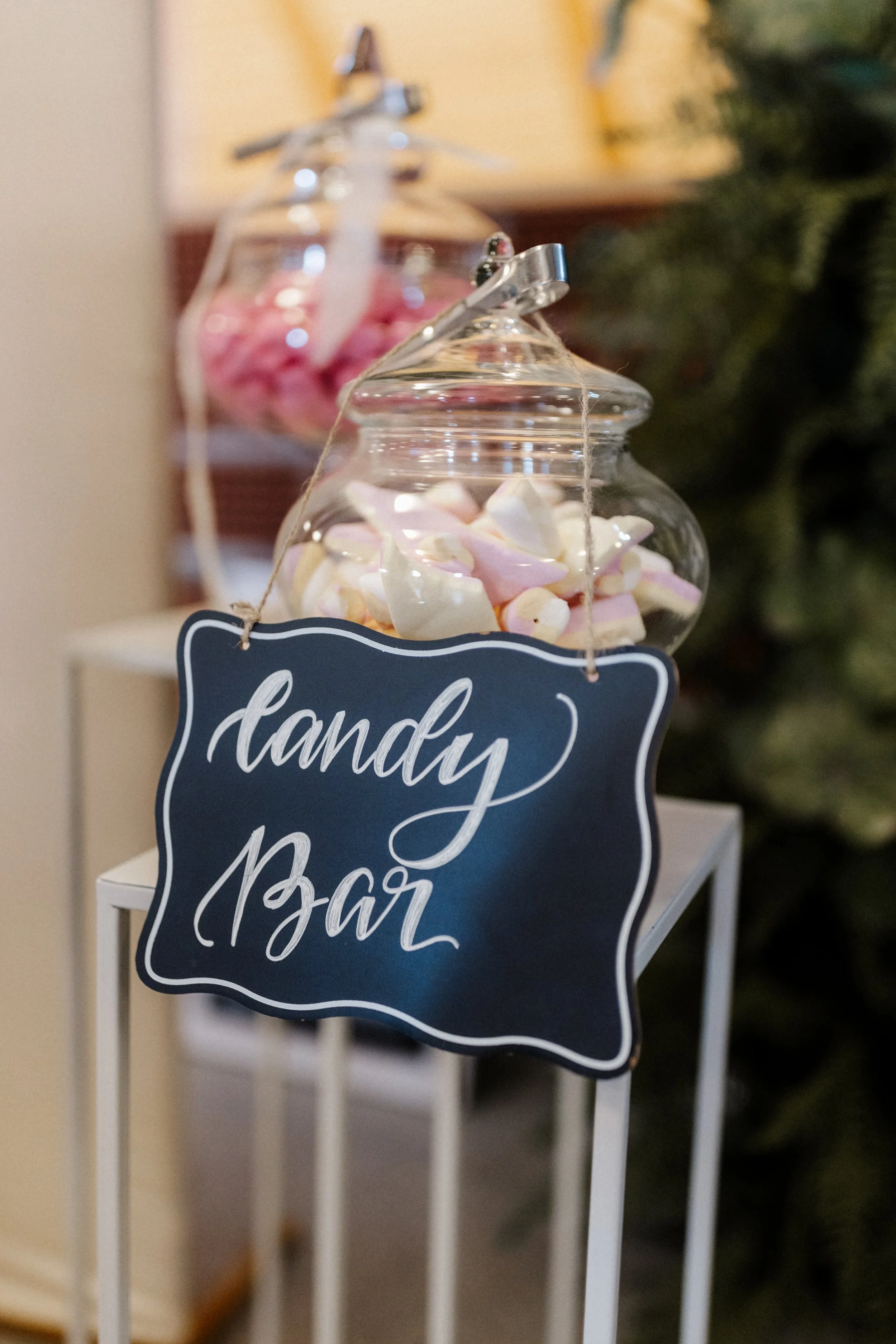 Glasschale mit Marshmallows auf einem weißen Tisch, Hand Lettering Schilder mit der Aufschrift "handy" und "Bar".