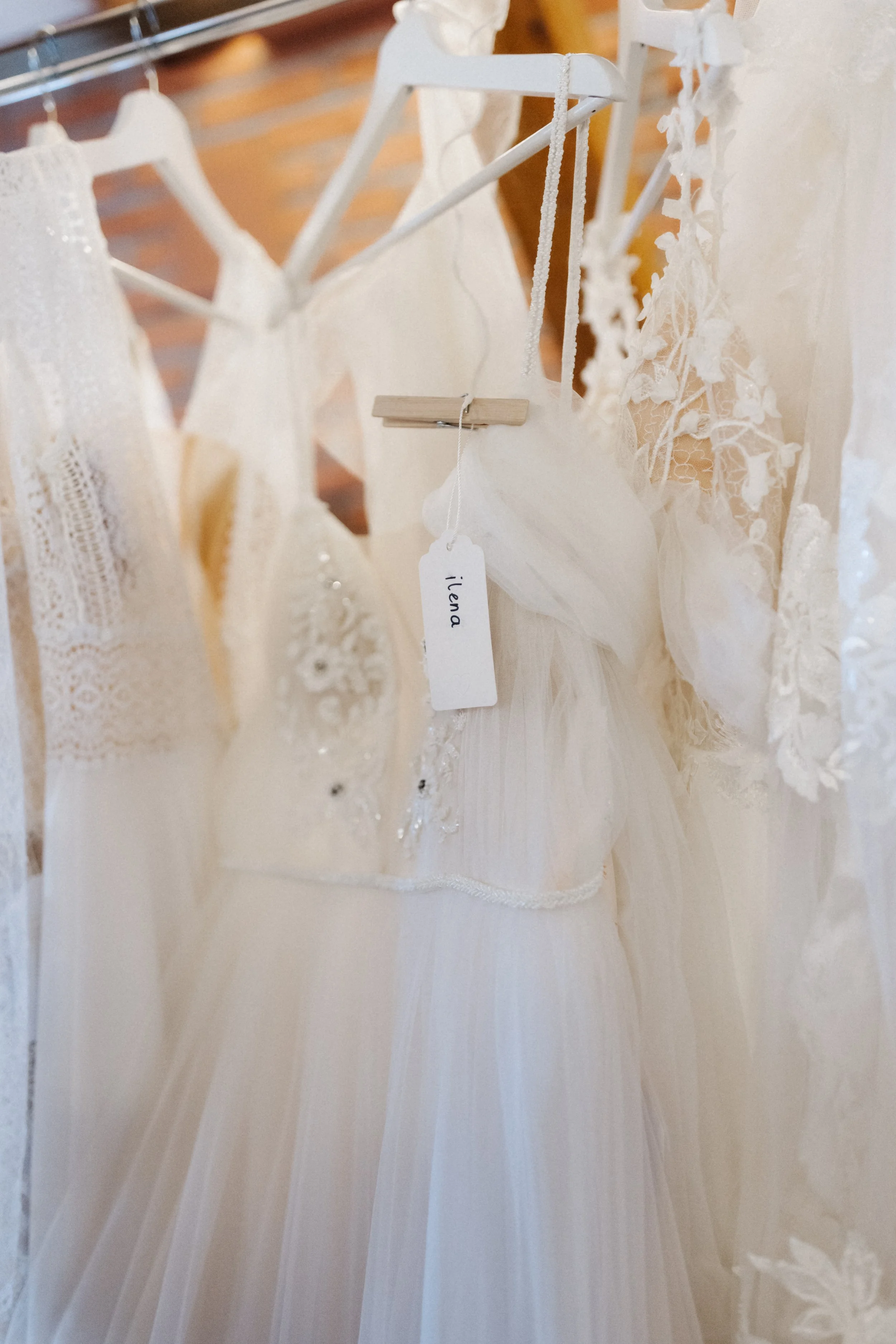 Weißer Kleiderbügel mit einem weißen Brautkleid aus Spitze und Tüll, das an einer Wäscheleine hängt.