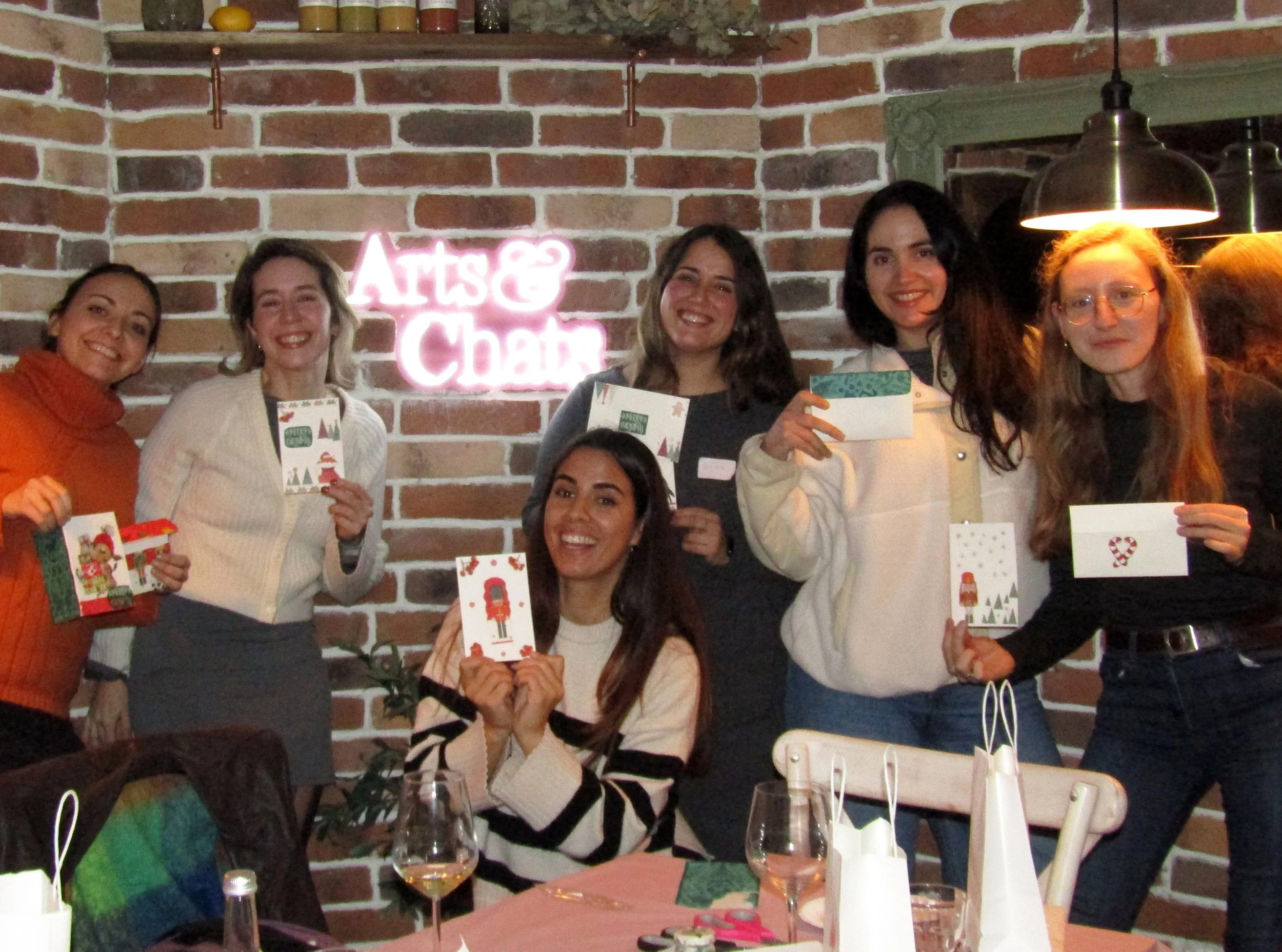 Modern wooden house with large window, set against a mountainous landscape with steep, rocky hills in the background.