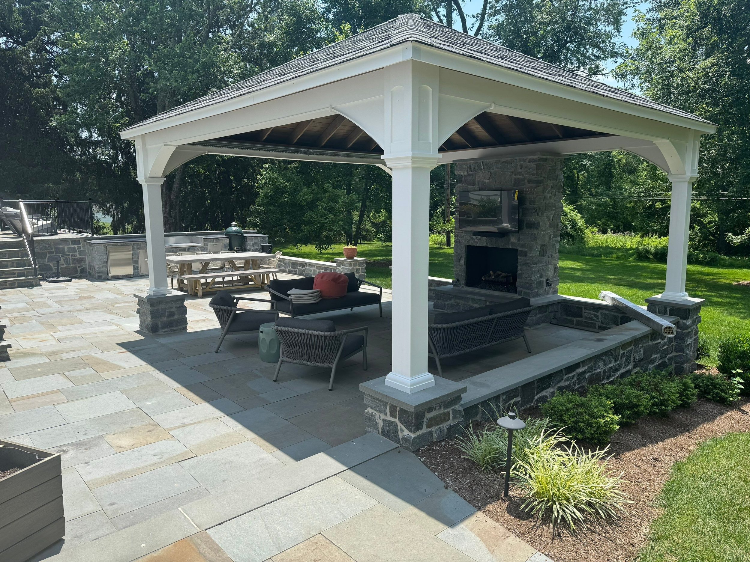 A 20x20 Pavilion with natural gas fireplace, outdoor TV, furniture, and infrared space heaters. An outdoor kitchen with fridge, griddle, and smoker.