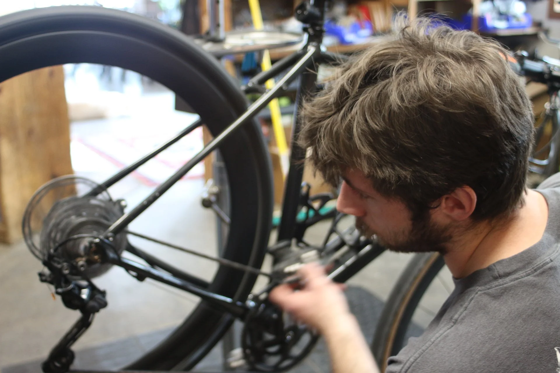 Man working on a bicycle in a workshop.