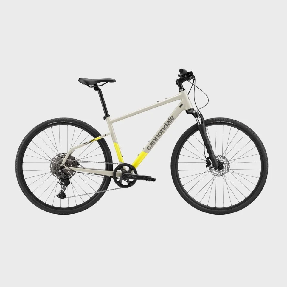 A Cannondale mountain bike with a cream and yellow frame, black tires, and front suspension fork, set against a plain light gray background.