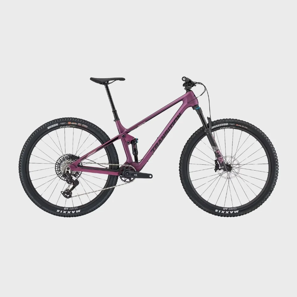 A purple Trek mountain bike with front and rear suspension, disc brakes, and Maxxis tires, photographed against a light gray background.