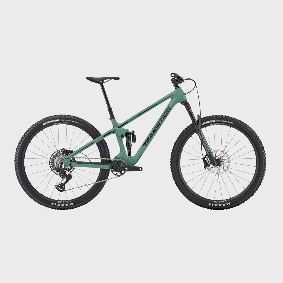 A teal full-suspension mountain bike with black tires and a black seat against a light grey background.