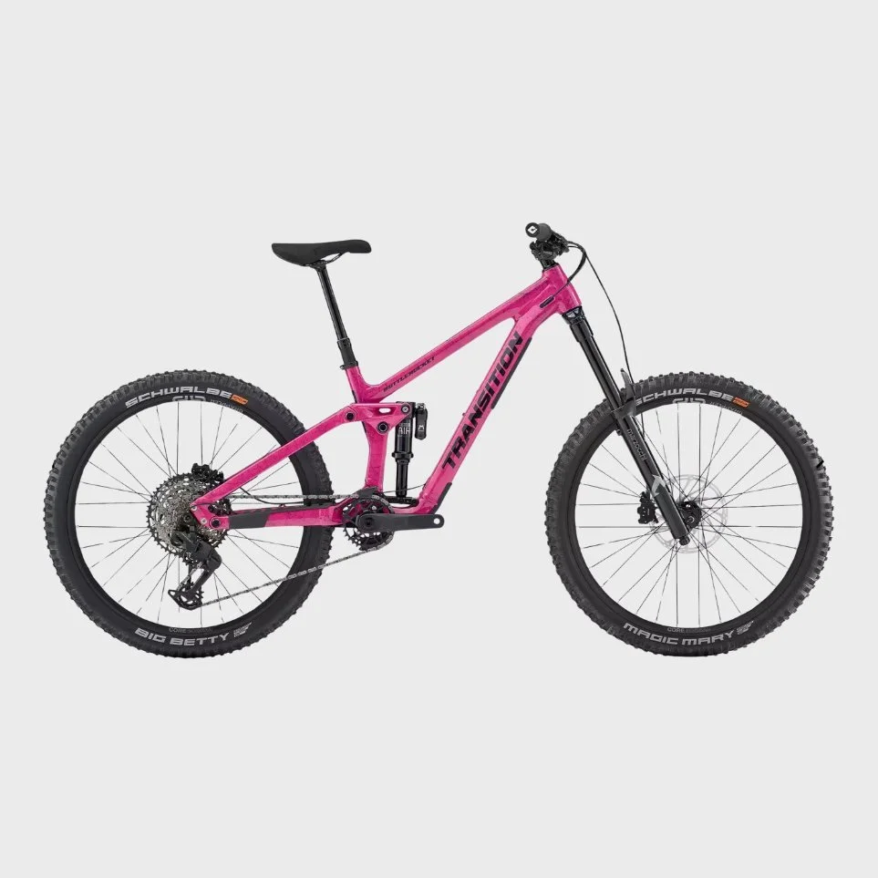 A pink full-suspension mountain bike with black tires against a gray background.
