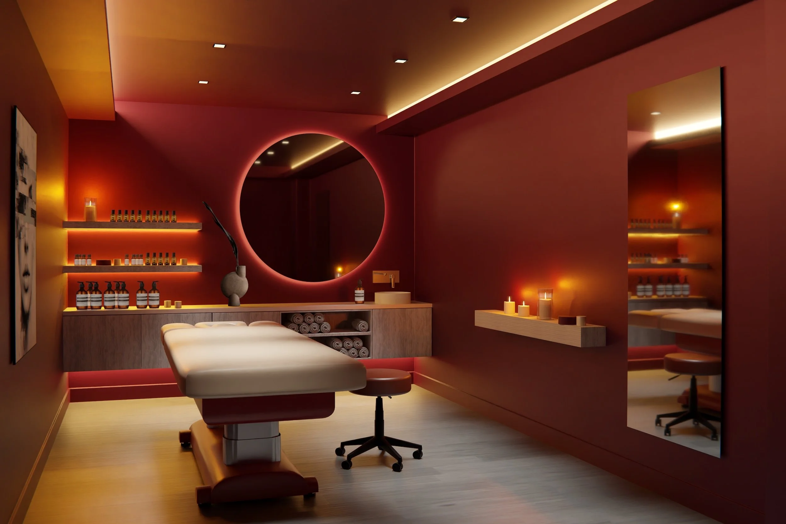 Une salle de massage ou spa avec des murs rose et un éclairage tamisé. Un lit de massage blanc, des candles, des étagères avec des bouteilles, un miroir rond, et un vase avec une branche décorative.