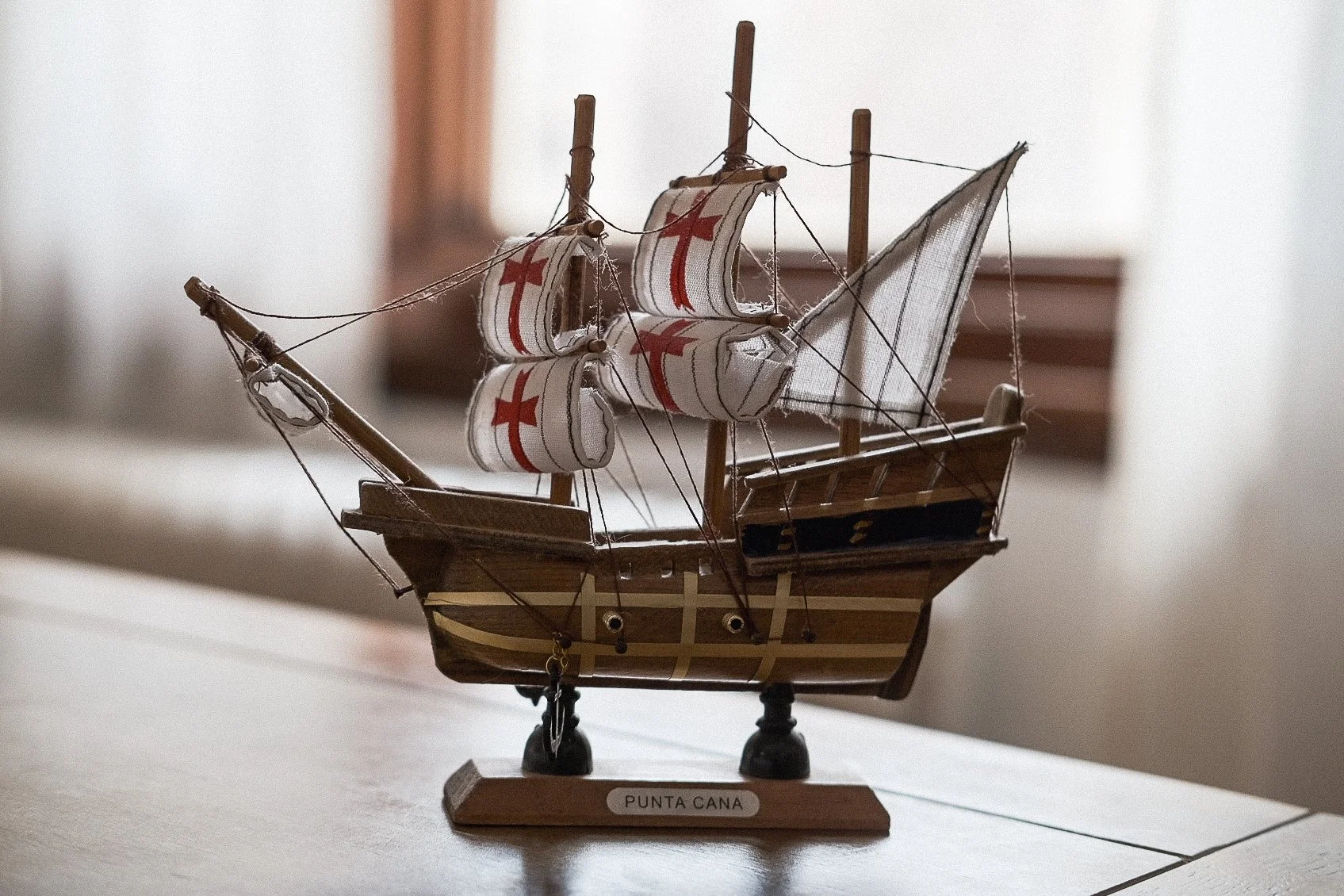 A detailed miniature model of a sailing ship with the label Punta Cana, displayed on a wooden base.