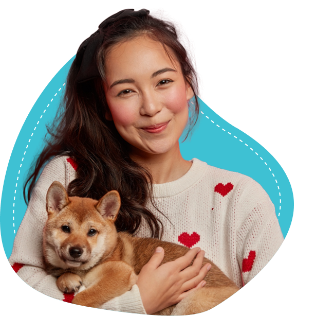 Young woman holding a Shiba Inu puppy, smiling, against a colorful geometric background.
