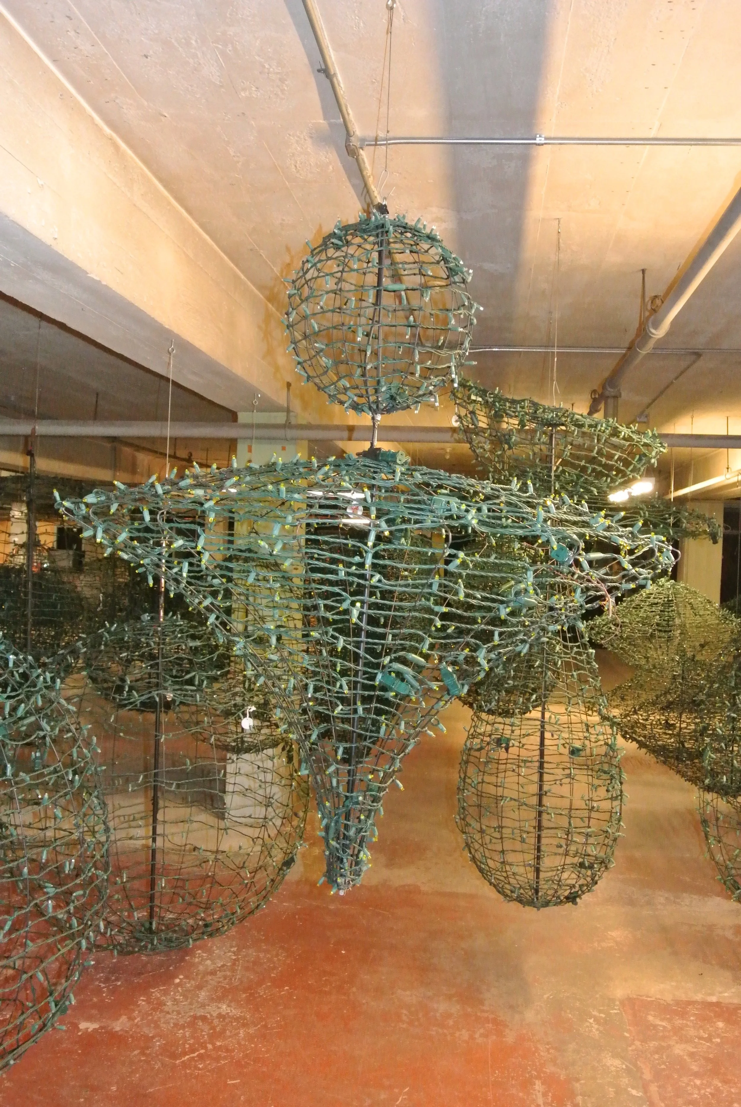 Hanging decorative light sculptures in a garage or industrial space.
