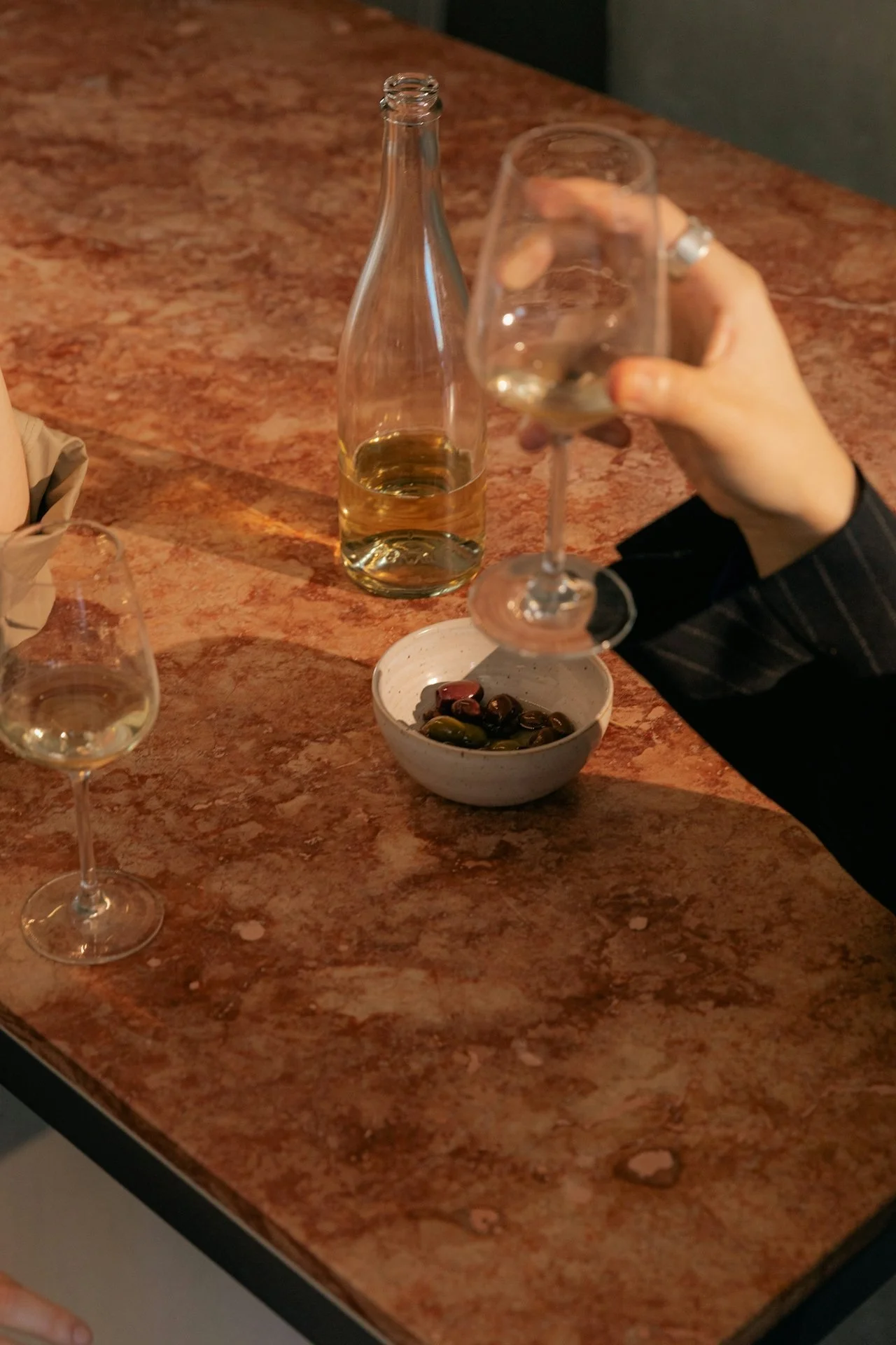 a hand takes some bread off of a table full of food