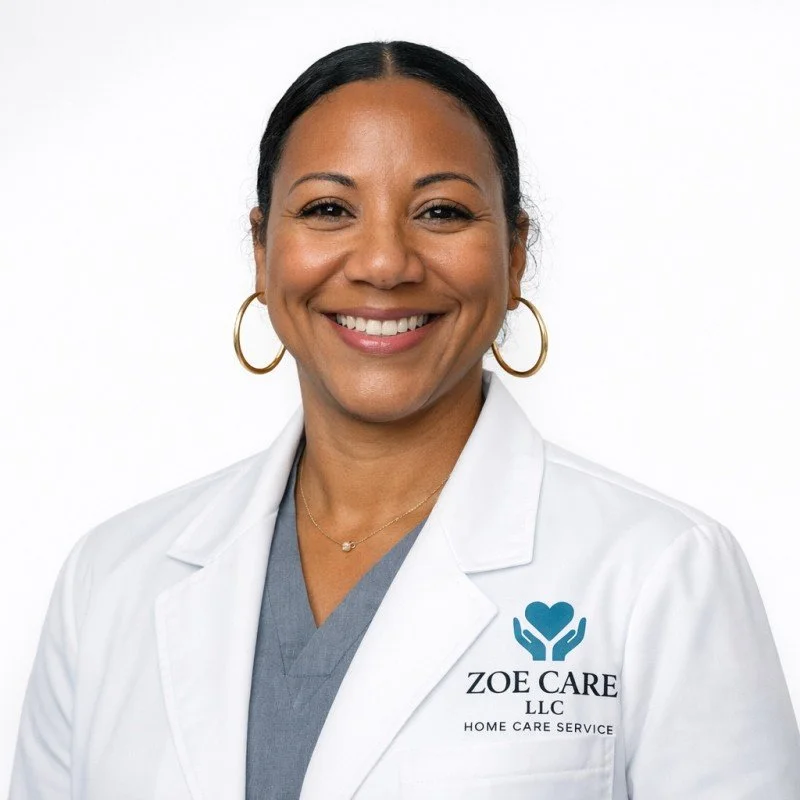 Smiling woman in white medical coat with Zoe Care LLC logo and gold hoop earrings
