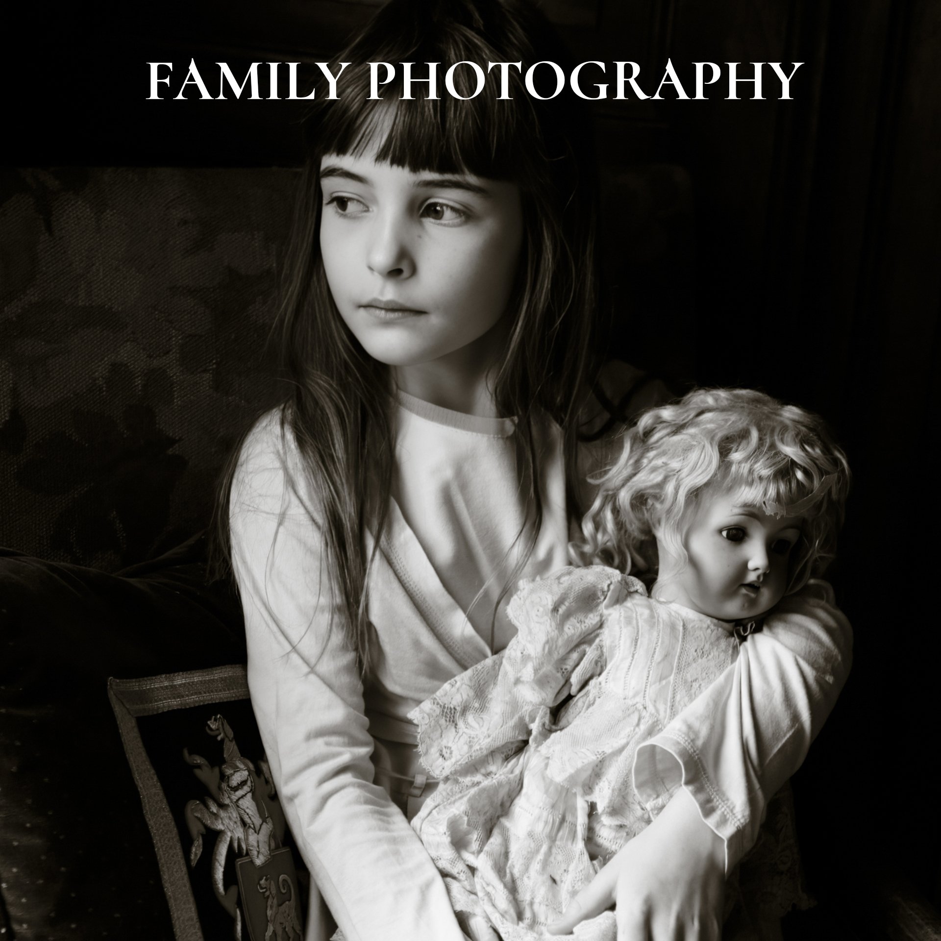 Black and white photo of a young girl holding a doll, with the text 'Family Photography' at the top.