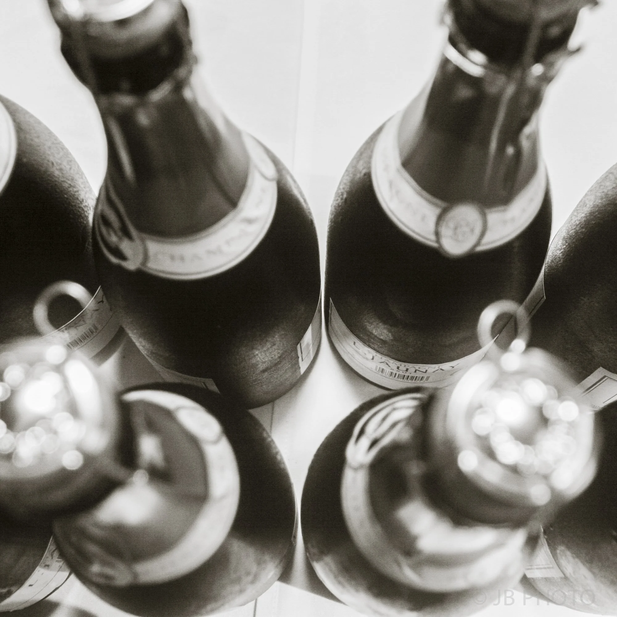 Top-down view of six bottles of beer arranged in two rows, shot in black and white.