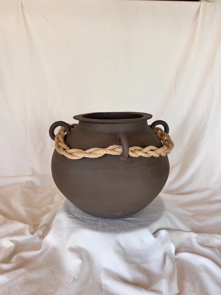 brown ceramic vase with rope