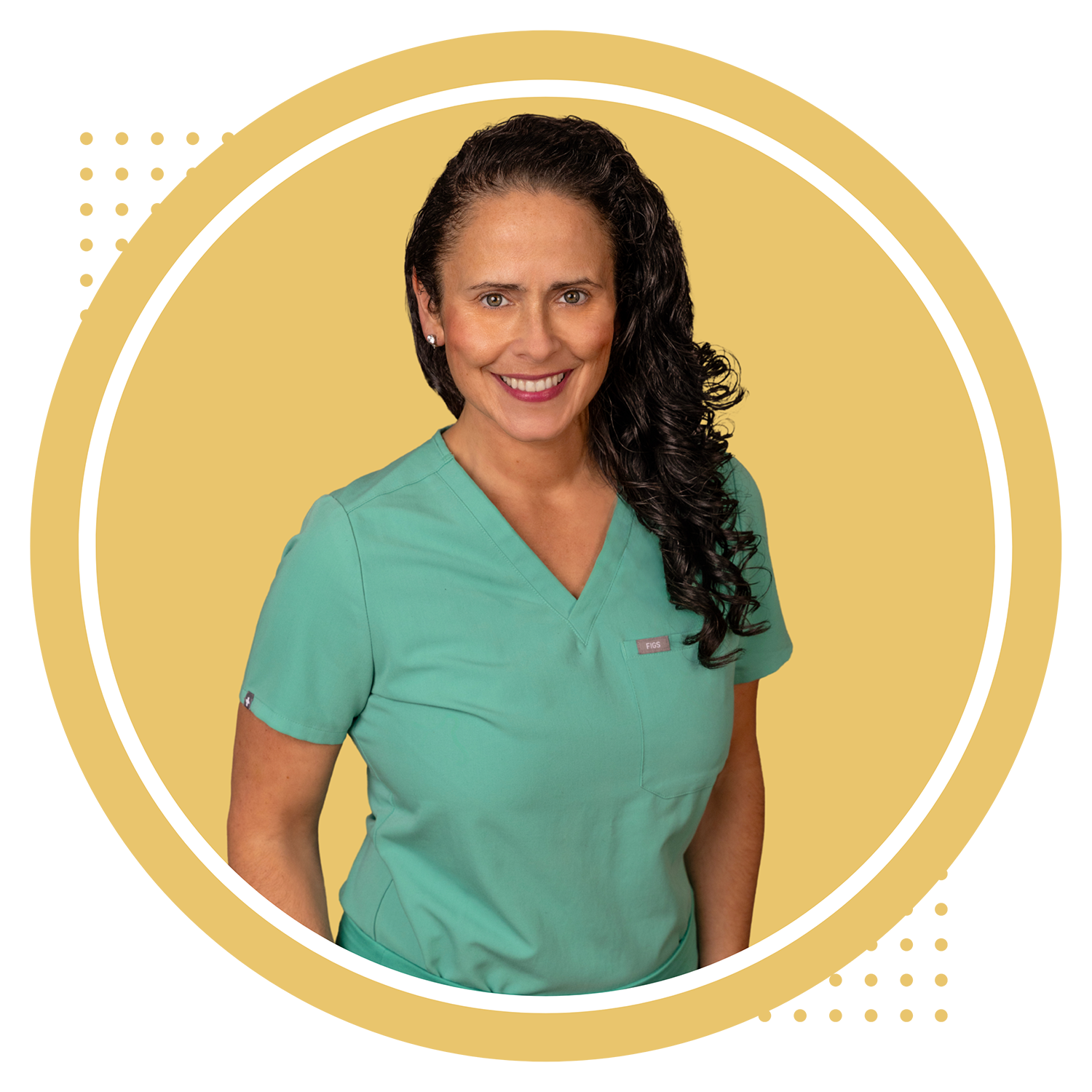 A woman in medical scrubs smiling in front of a yellow background.