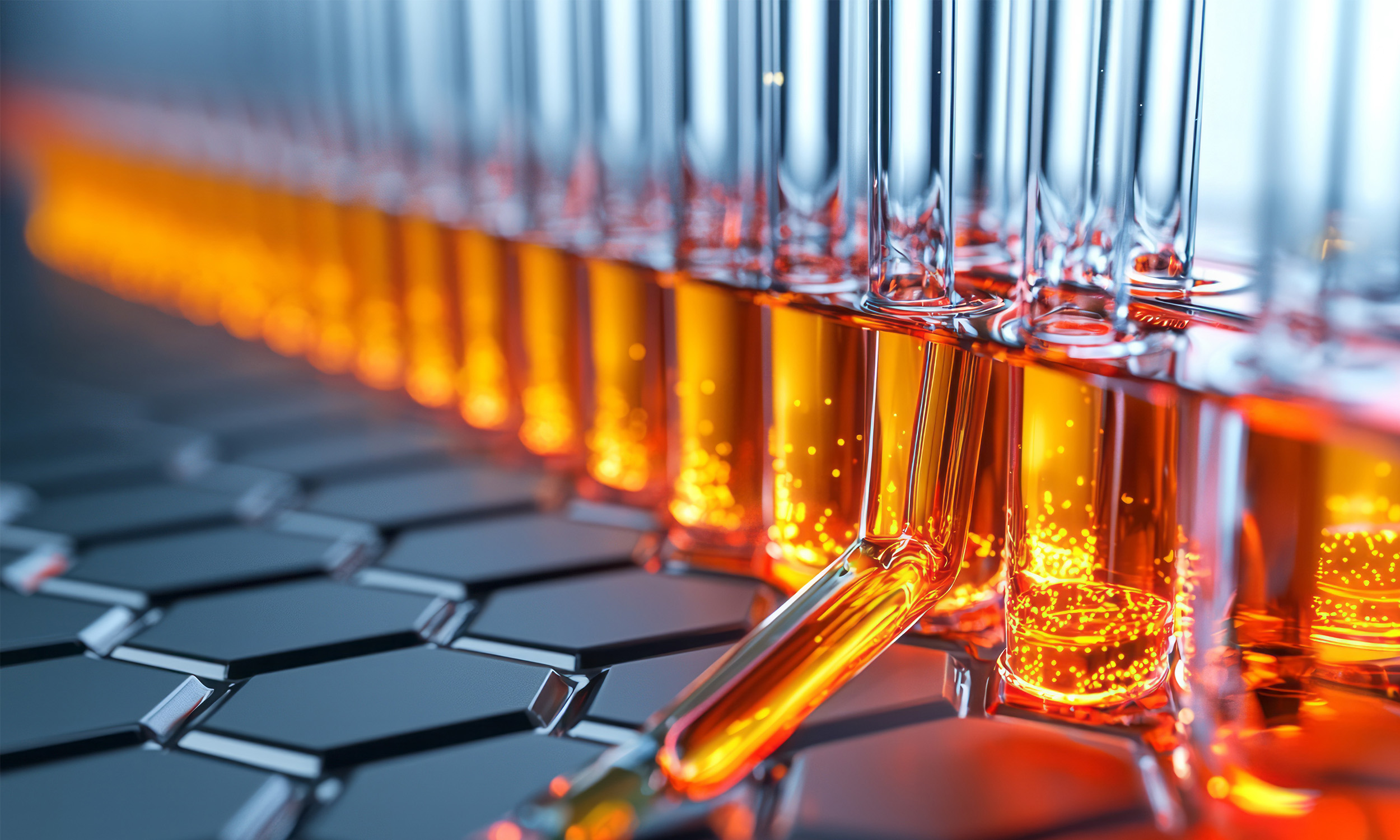Close-up of laboratory test tubes with orange liquid placed on a black hexagonal patterned surface.
