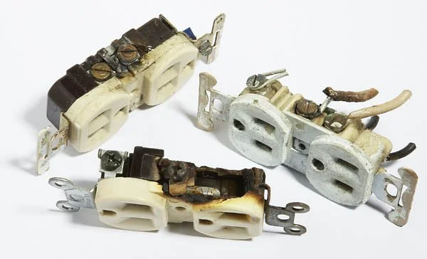 Three worn-out electrical outlet adapters with visible rust and corrosion