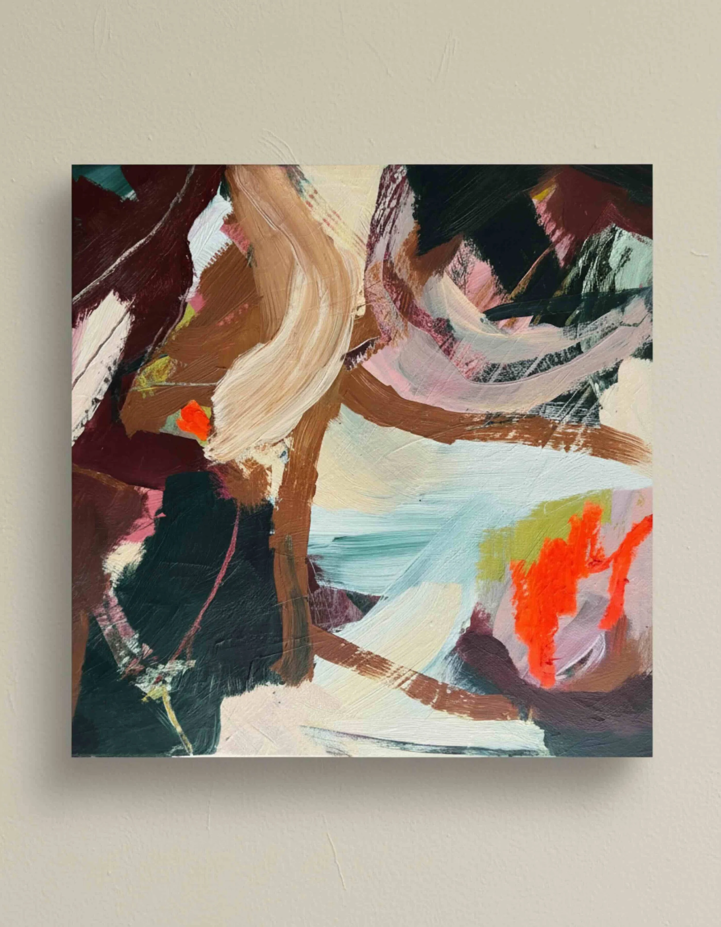 Abstract painting with bold brushstrokes in various shades of brown, black, beige, pink, red, and white mounted on a beige wall.