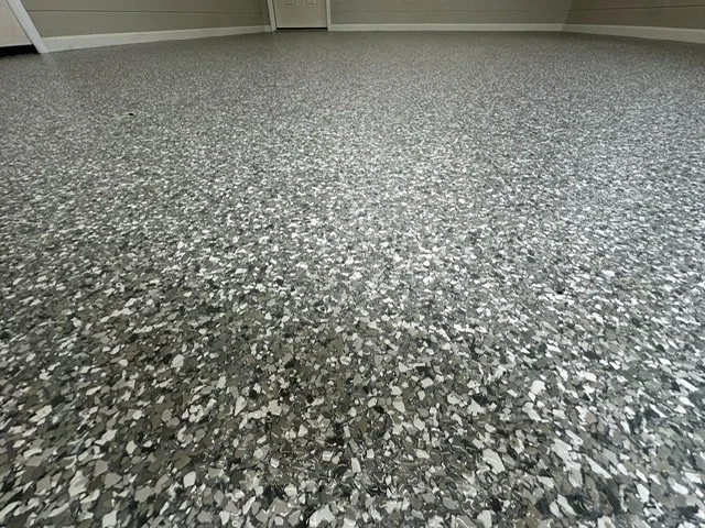Close-up of a speckled gray and black terrazzo floor in a room.