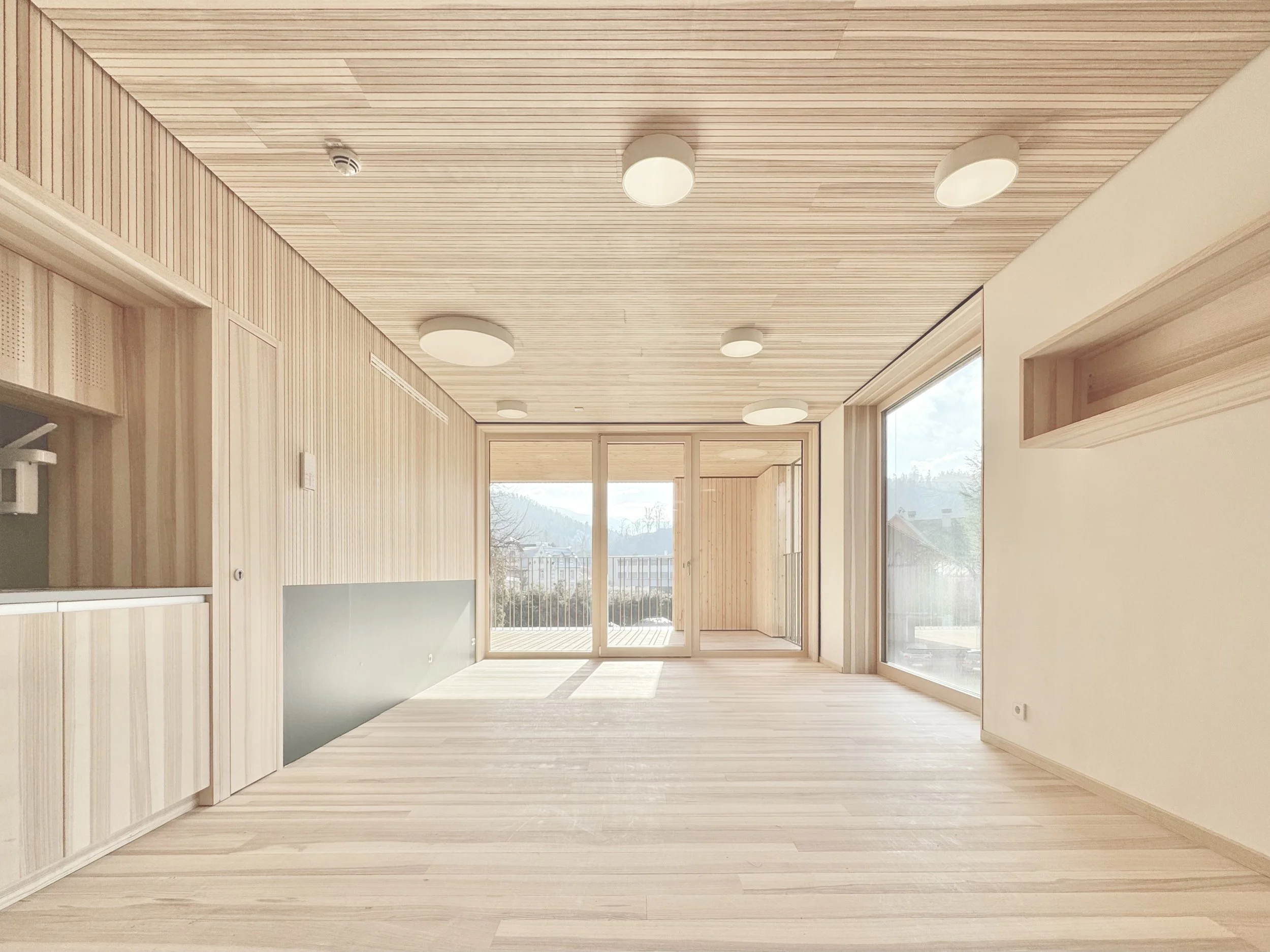 Kinderhaus Rankweil Markt | Gruppenraum Aussen | Massivholz und Lehmwände schaffen ein gesundes und natürliches Raumklima | Jeweils 2 Gruppenräume mit gemeinsamer Spielloggia