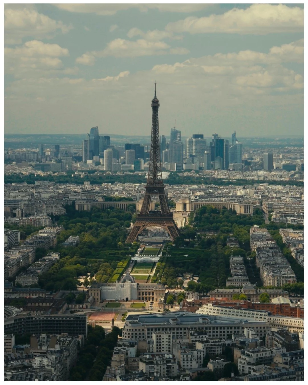 Aerial view of the Eiffel Tower in Paris, France, with the city skyline and skyscrapers in the background.