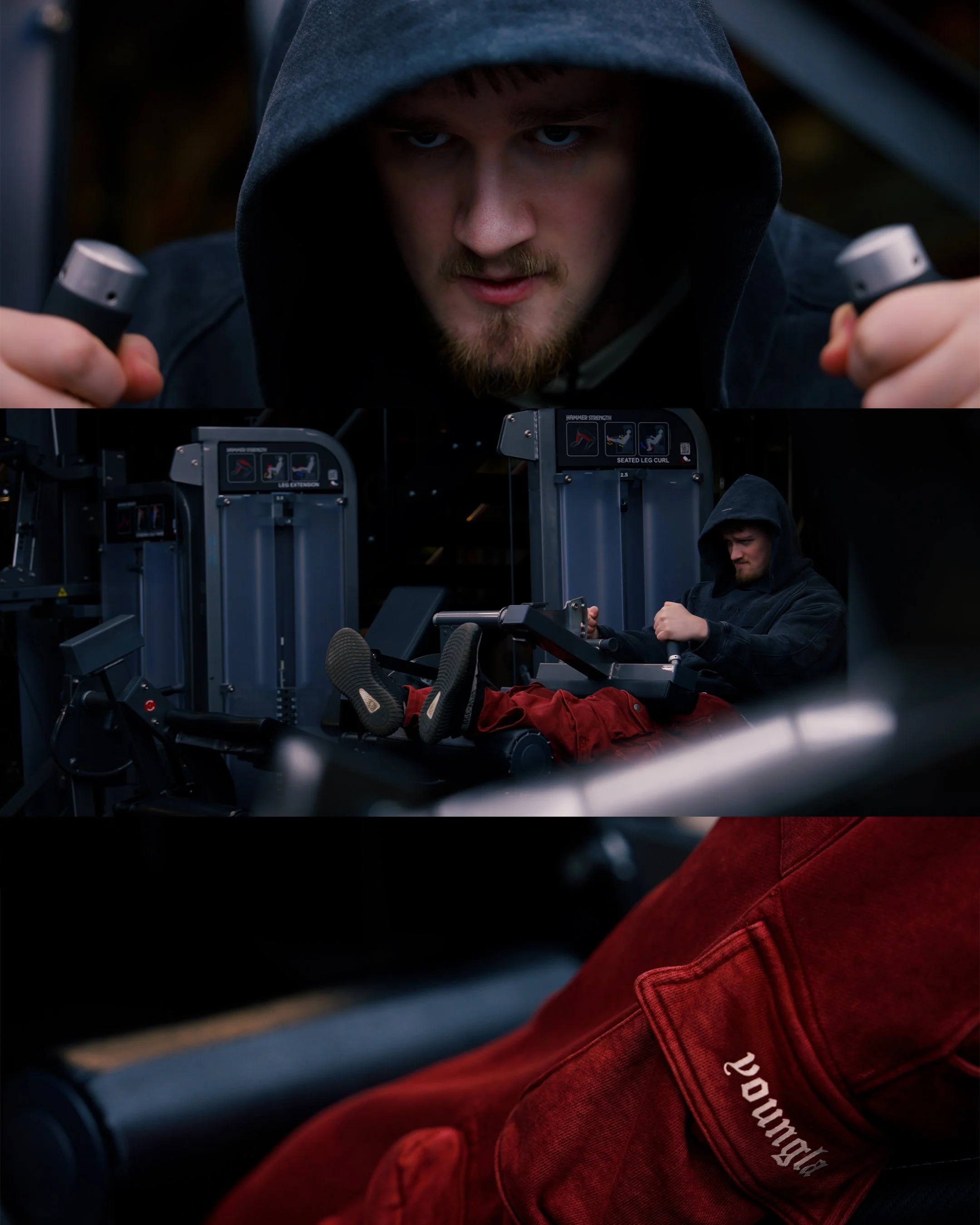 A young man in a dark hoodie using gym equipment, focused on his workout, inside a gym with various workout stations.