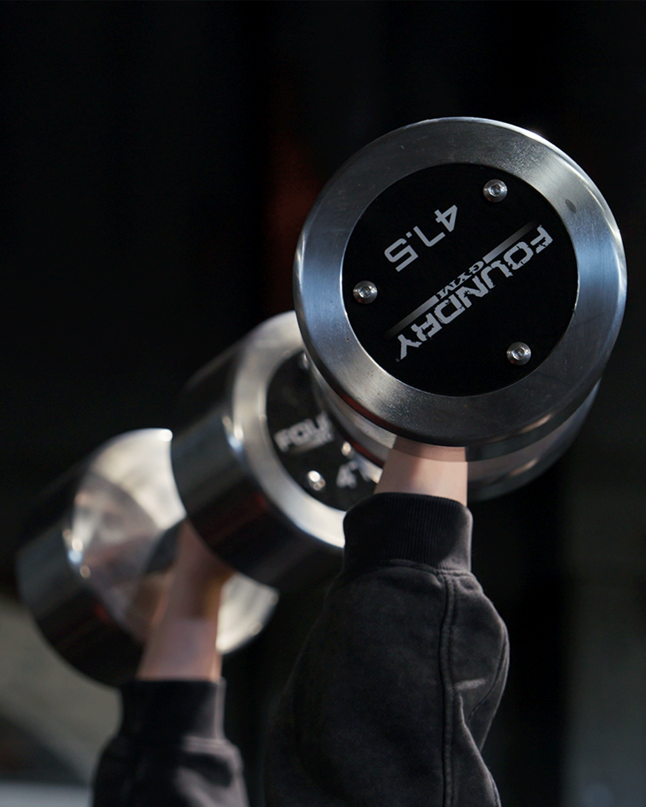 Person lifting a large dumbbell labeled 'FOURDZY 45'.