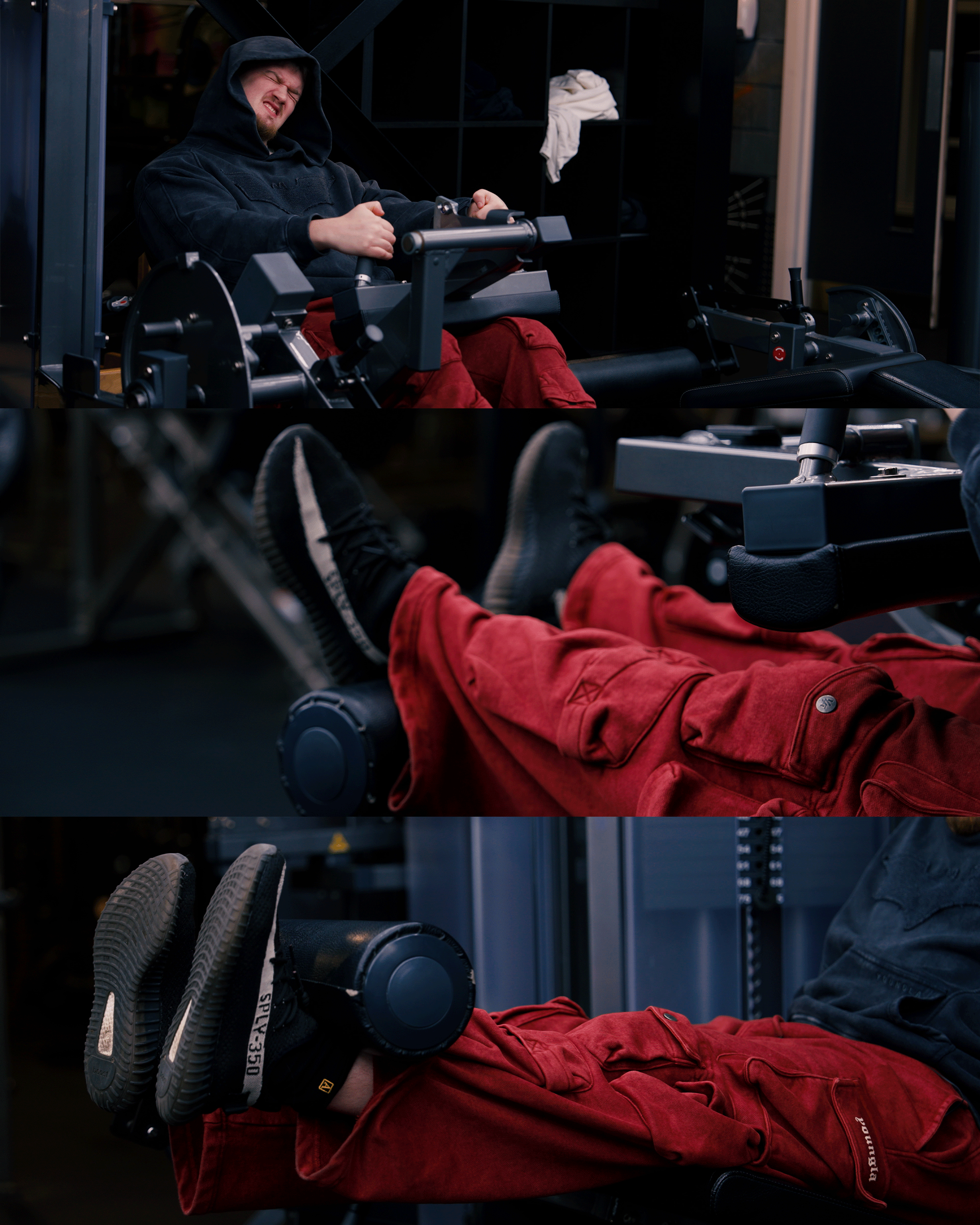 A person in a black hoodie and red pants working out on a rowing machine, showing a strained facial expression, with close-up of their legs and shoes.