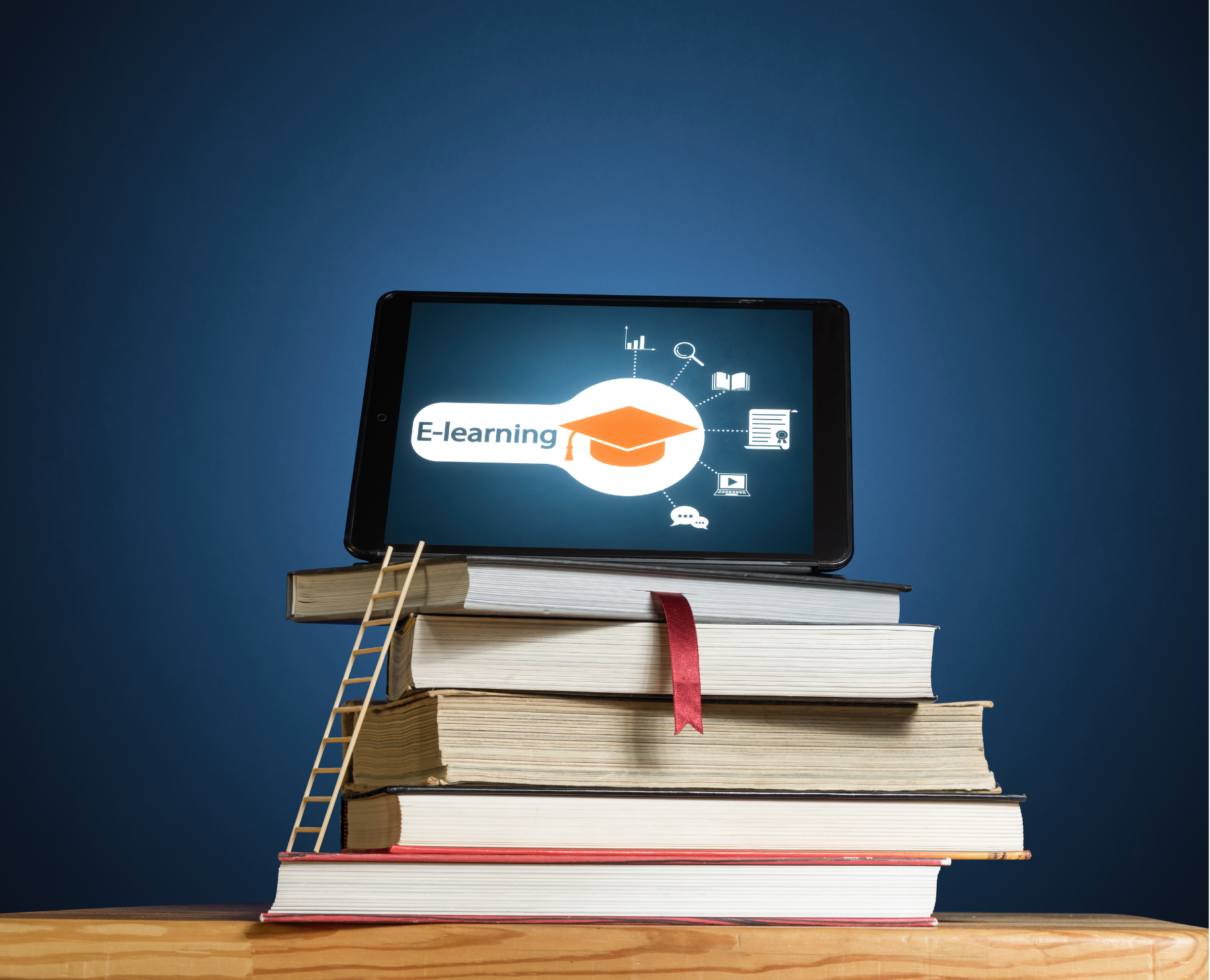 ipad with e-learning icon visible on a stack of books. There is a mini-ladder leading from the bottom book to the ipad.