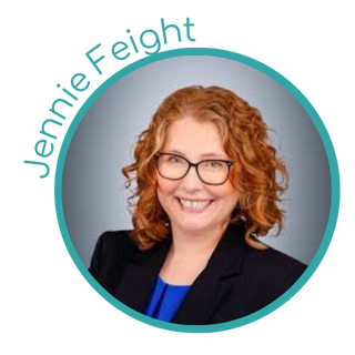 A woman with curly red hair and glasses, smiling in a professional portrait photo.