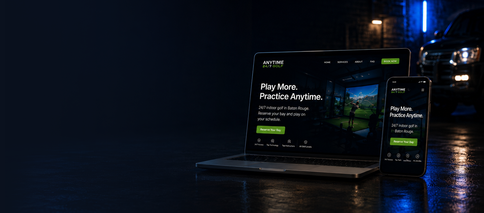 A laptop and smartphone on a wet surface in a dark setting, displaying a website for indoor golf called 'ANYTIME 24/7 GOLF'. The website features the slogan 'Play More. Practice Anytime.' and has a green button labeled 'Reserve Your Bay'. There are cars and blue neon lights visible in the background.