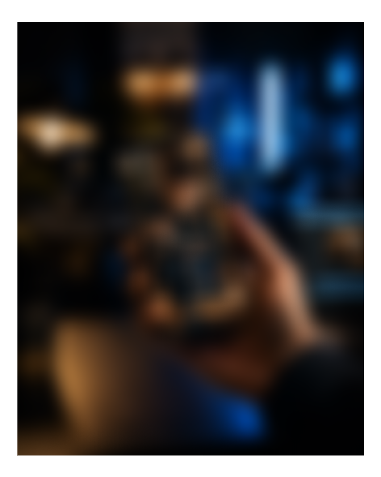 A person playing a guitar with a blurred background of a bar or restaurant setting.