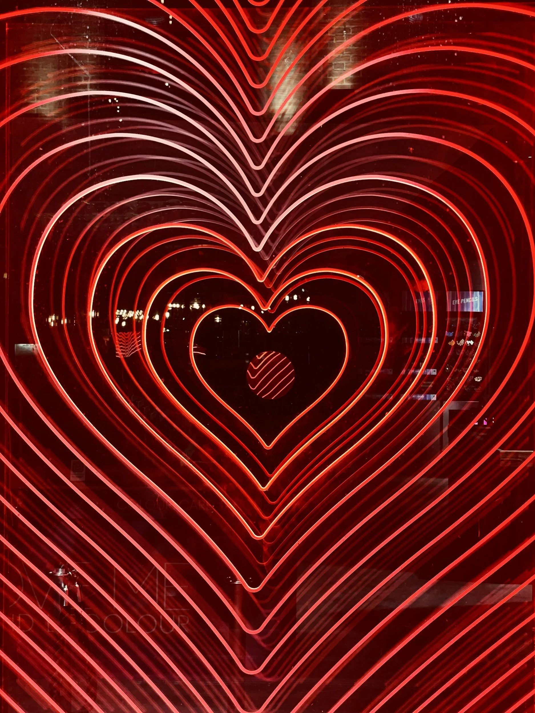 Multiple illuminated red heart shapes in a layered pattern, creating a tunnel-like visual effect.