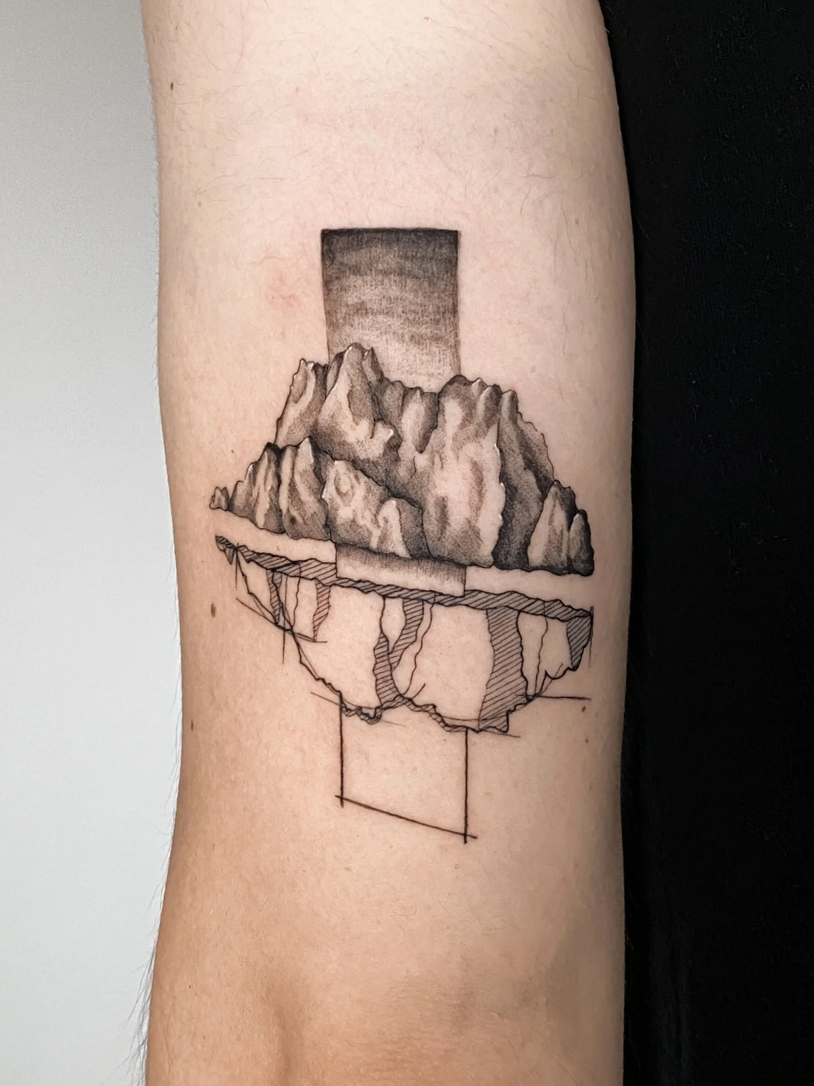 Tattoo of a mountain landscape with an architectural geometric base.