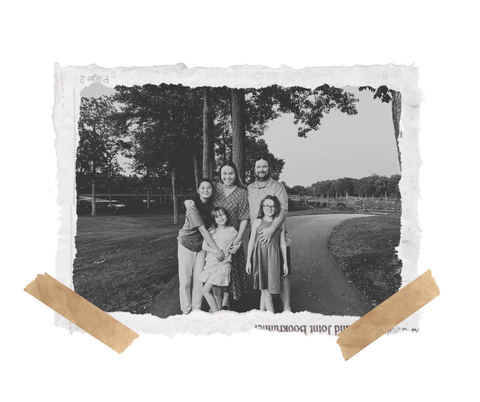 A black and white family photo of five people standing outdoors on a park trail.