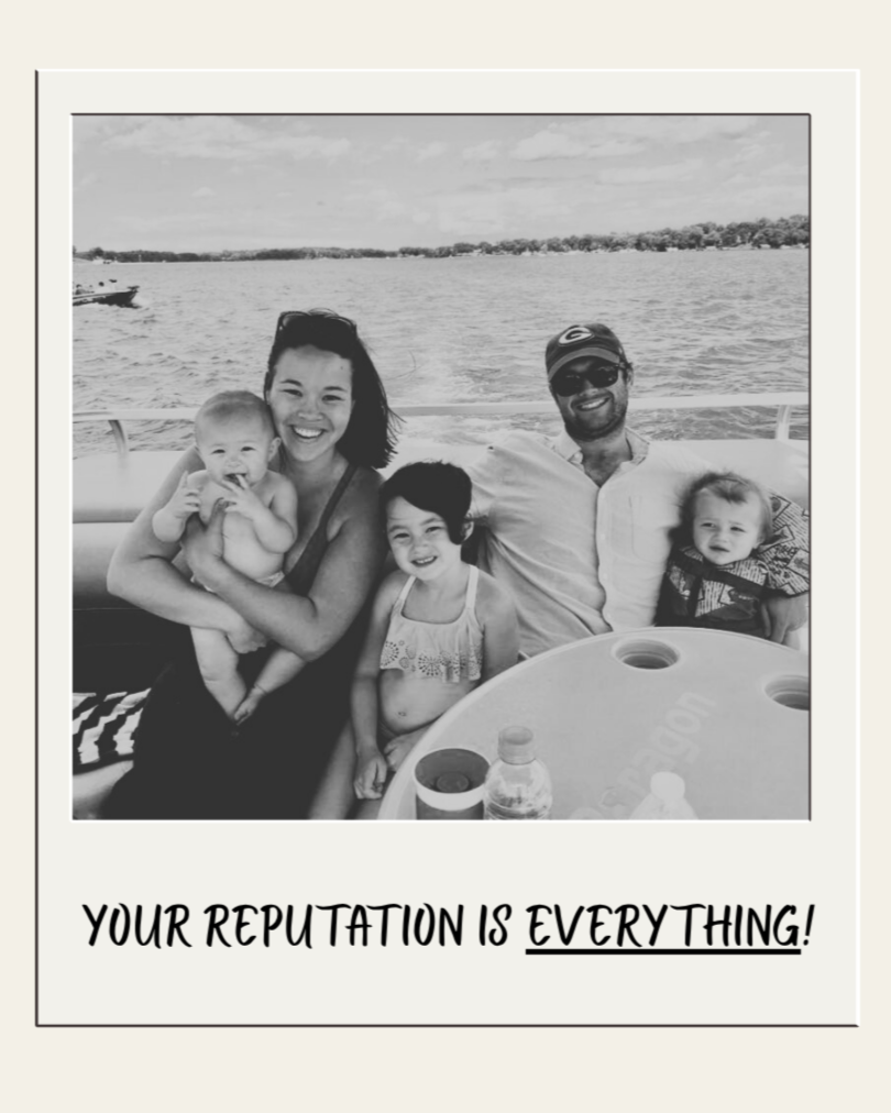 A family of five enjoying a boat ride on a lake, smiling at the camera, with the water and distant shore in the background.