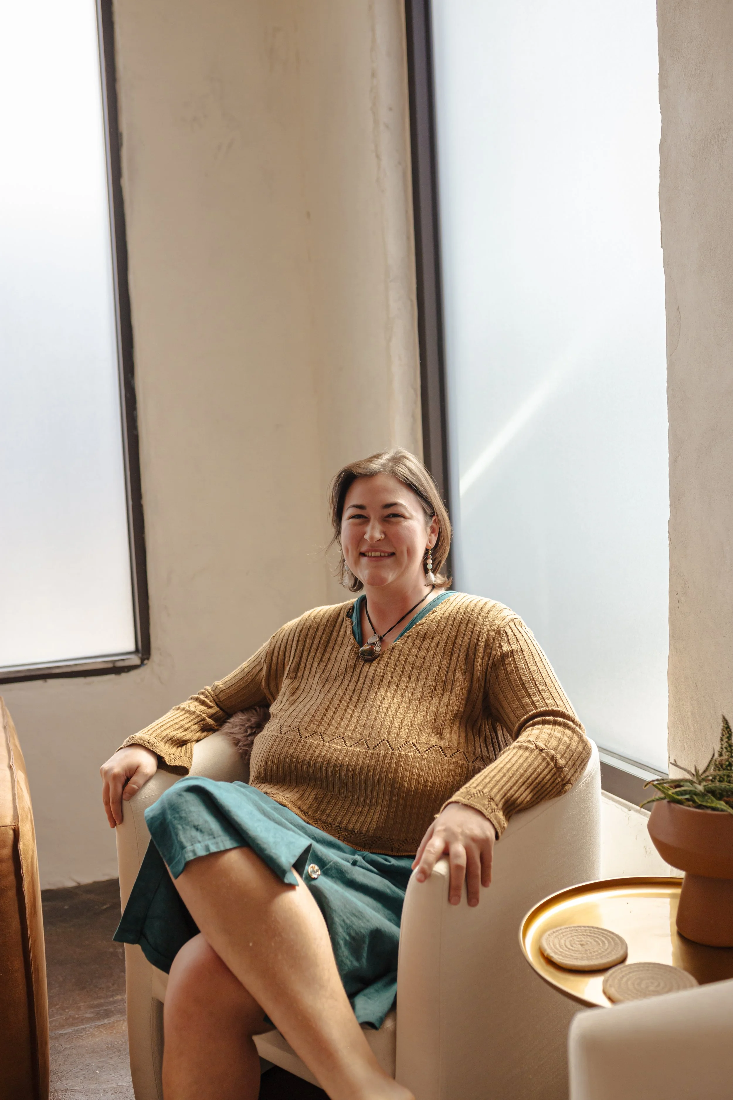 Massage therapist Kelby seated in a calm spa setting in Oklahoma City