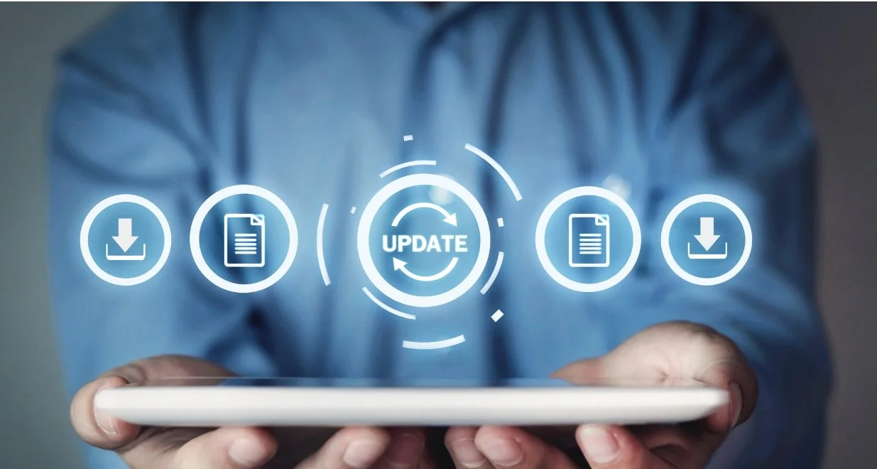 A person holding a smartphone with digital icons hovering above, including download, document, and update symbols, indicating software or app update process.