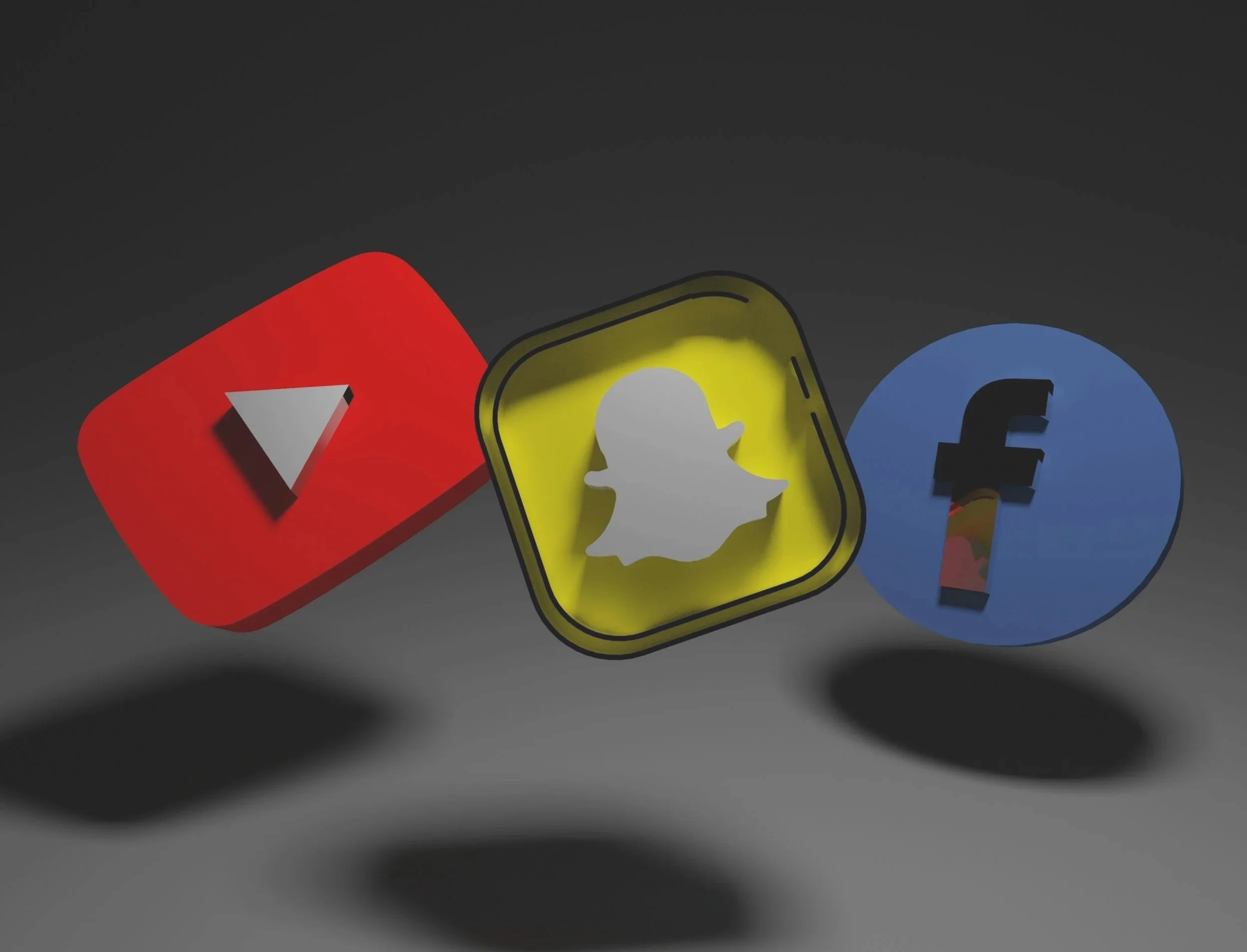 Iconos de YouTube, Snapchat y Facebook flotando en un fondo oscuro.