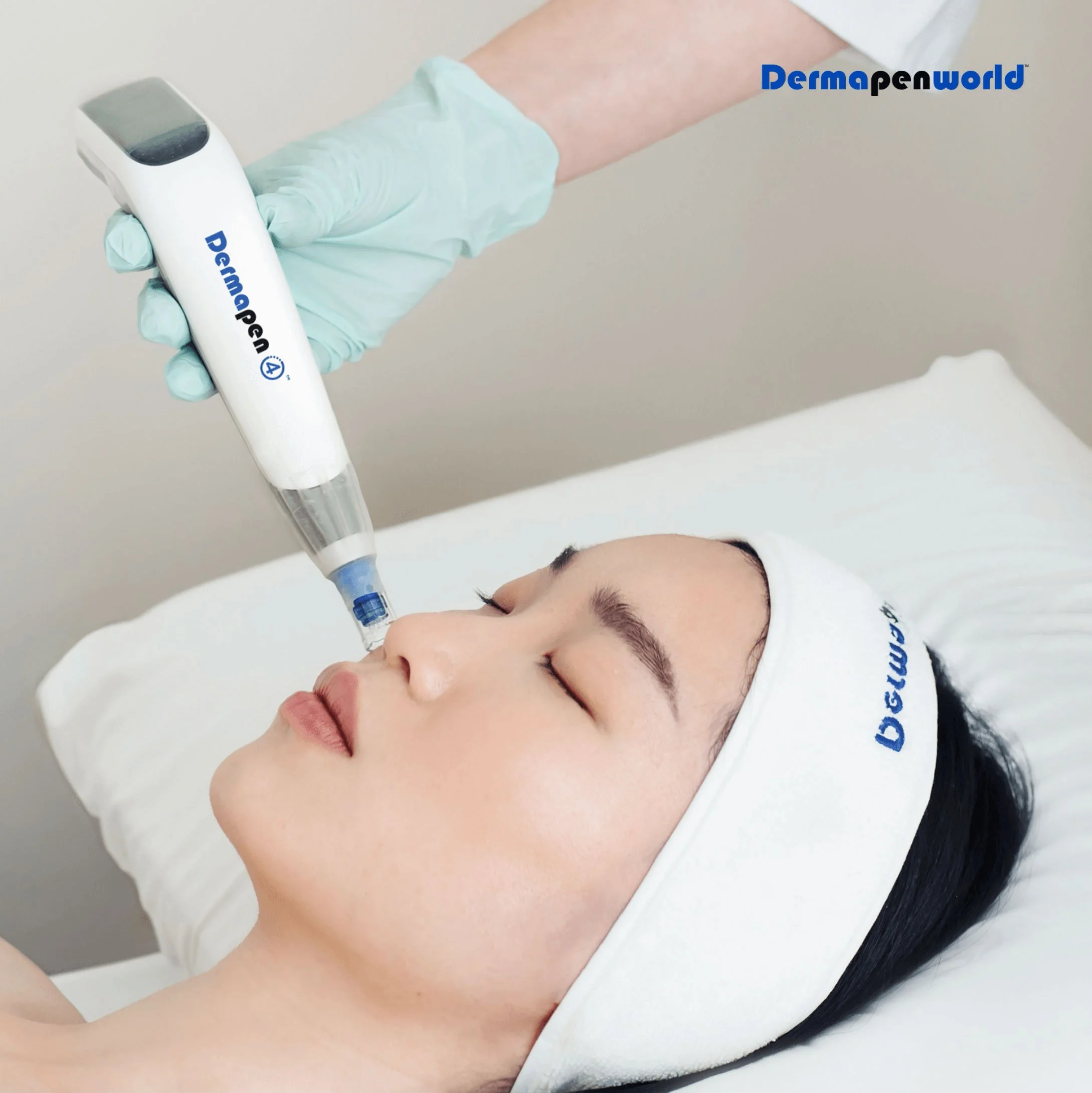 A woman lies with her eyes closed receiving a cosmetic facial procedure using a Dermapen device,