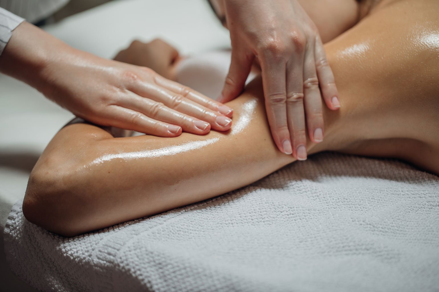 Close-up of person receiving a massage with oil, lying on a towel.