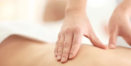 Close-up of a person receiving a massage on their back.