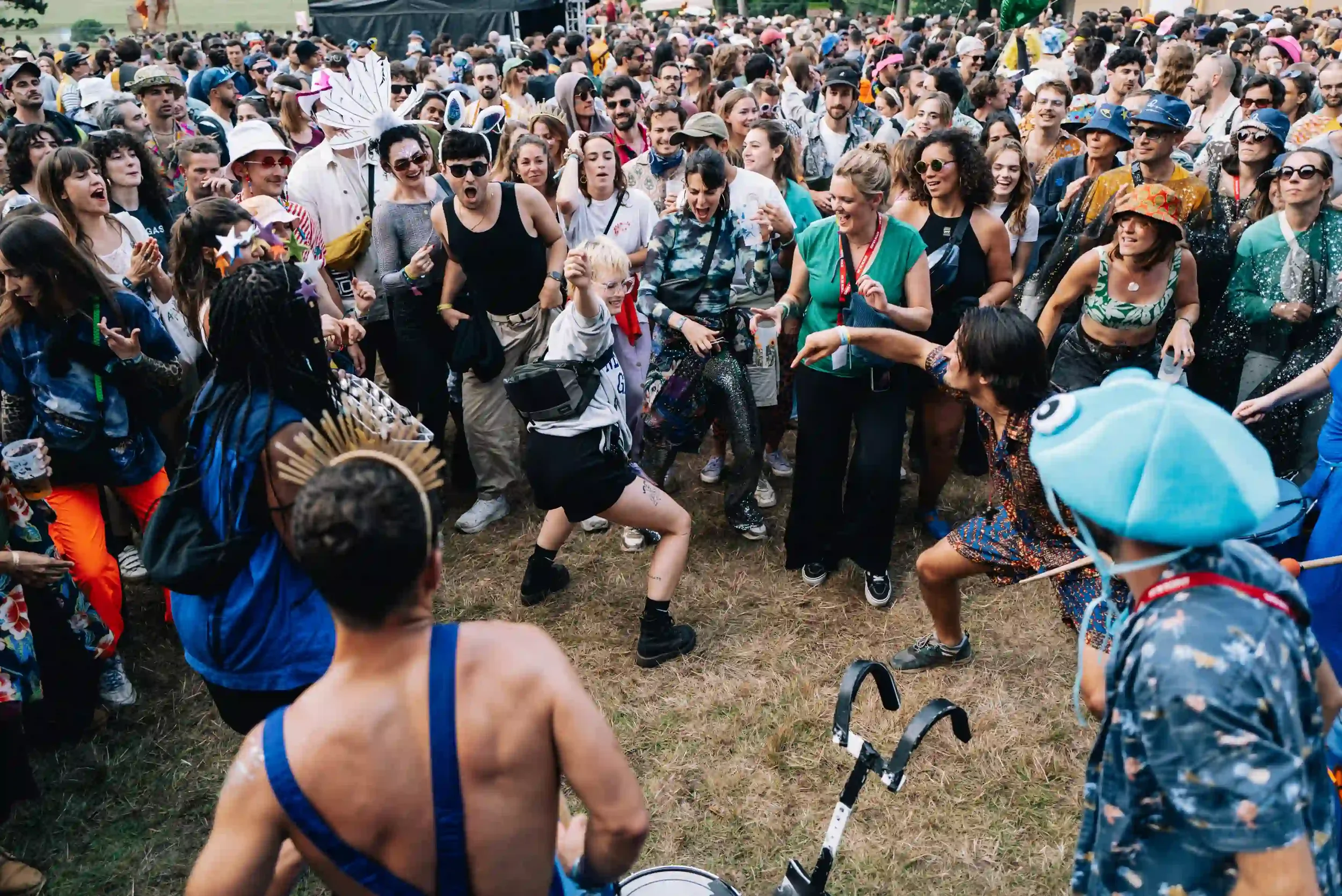 ue de dos des membres de la Drumteam en pleine performance face à une foule enthousiaste qui s'amuse et danse au festival Pete the Monkey. Photo : Antoine Sorel