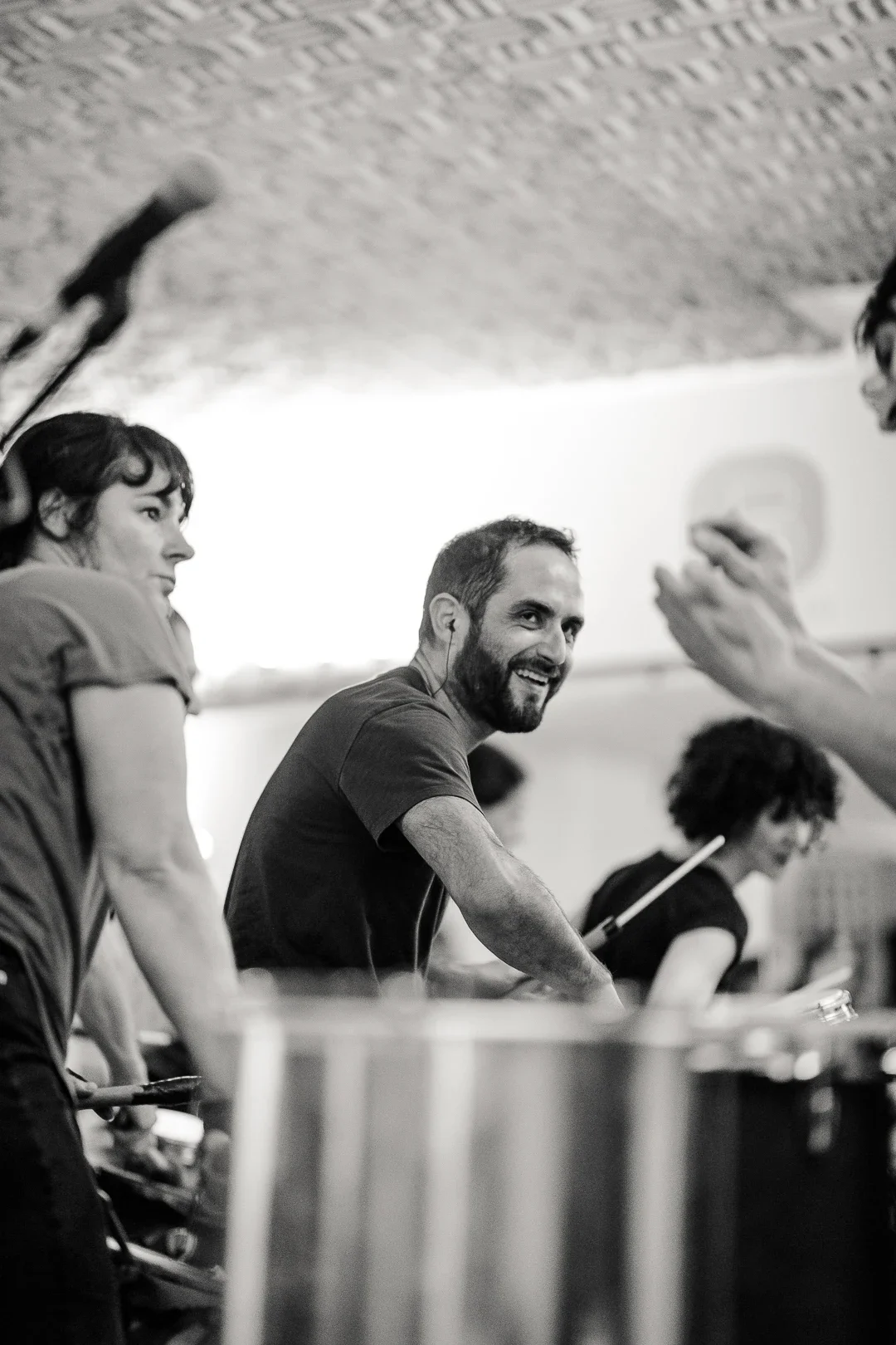 Portrait en noir et blanc de quatre membres de la Drumteam marchant avec complicité dans une rue parisienne, illustrant la force du collectif. Photo : Studio Olympe