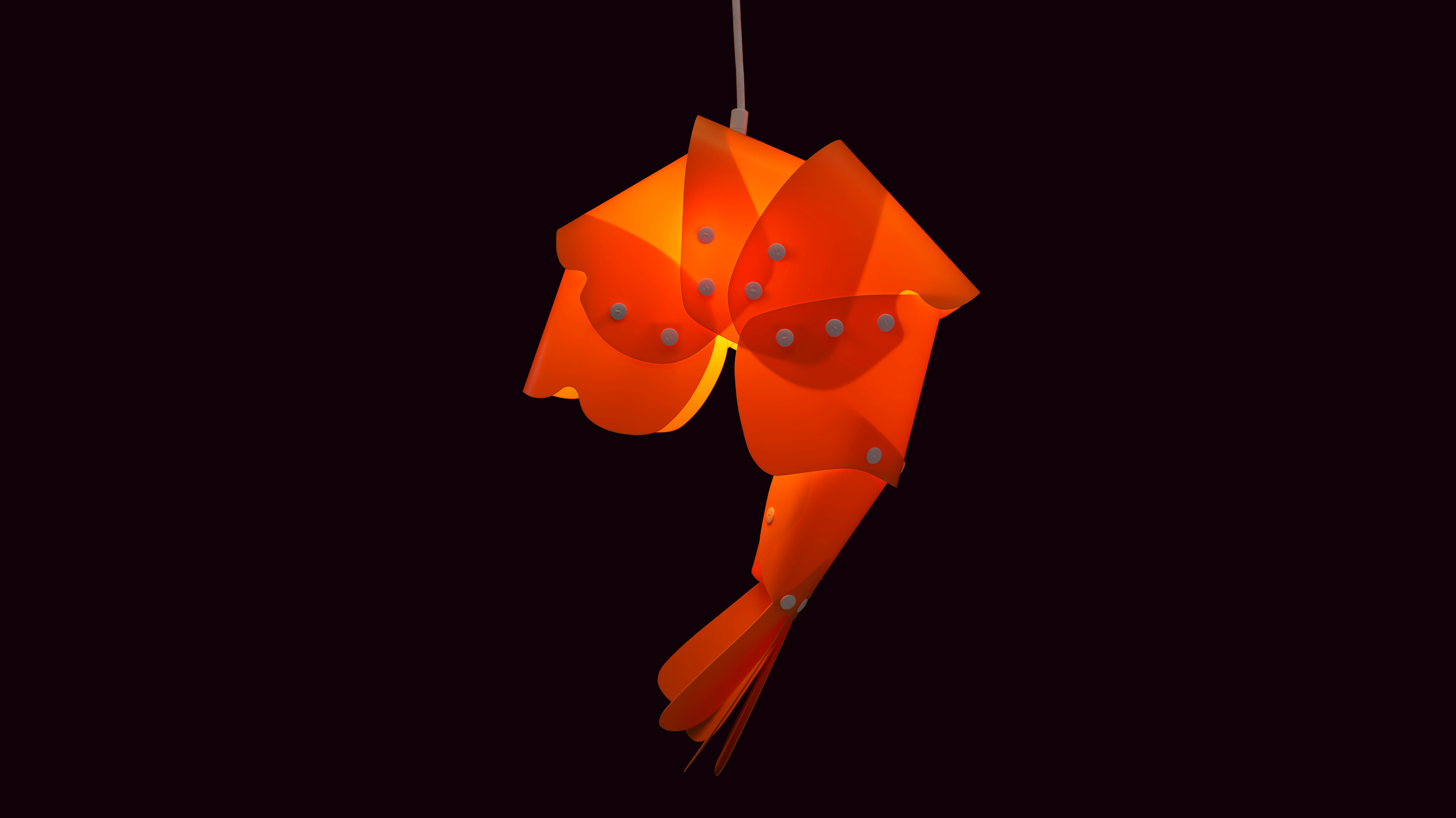 Orange pendulum lamp with petal-like design hanging against a black background.