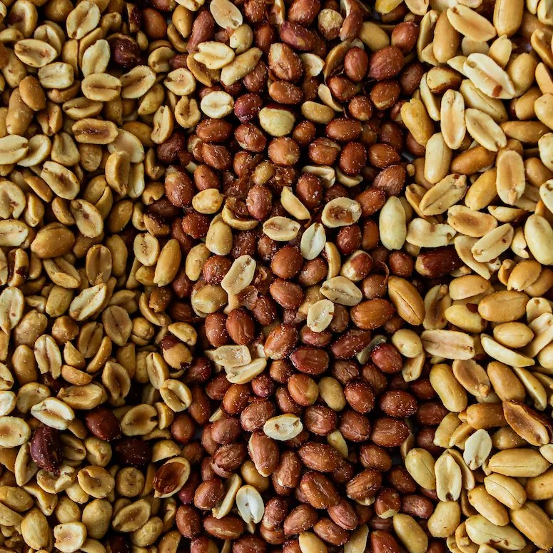 Multiple types of peanuts laying on a table.
